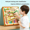 A young boy is using a wooden magnetic maze puzzle board to train color classification and improve concentration.