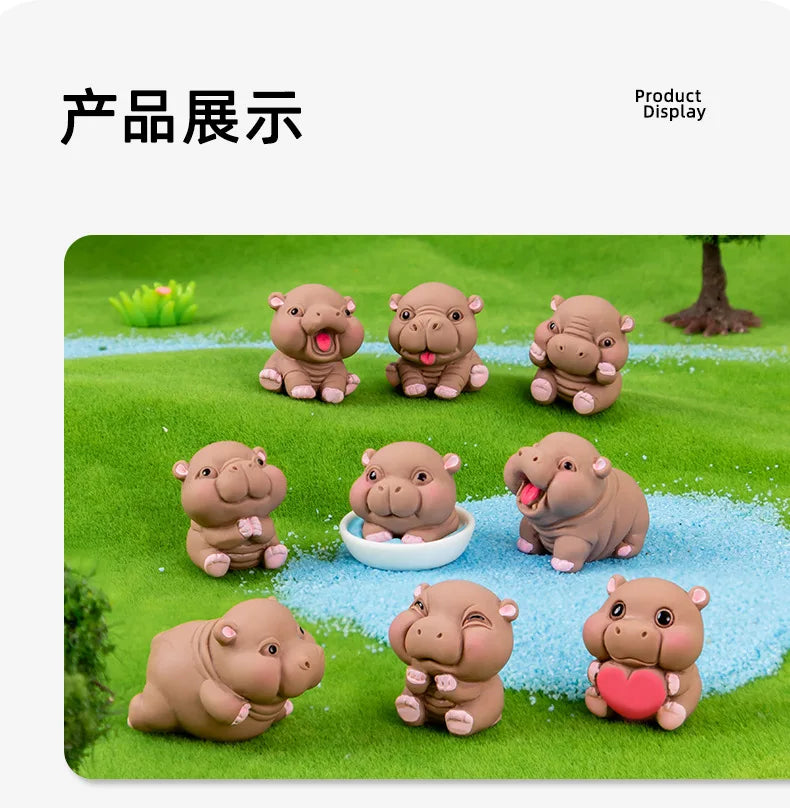 A display of several cute mini hippo resin figurines arranged on a green, grassy surface.