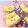 Yellow banana shaped squishy stress relief toy with a bear face design in clear plastic packaging