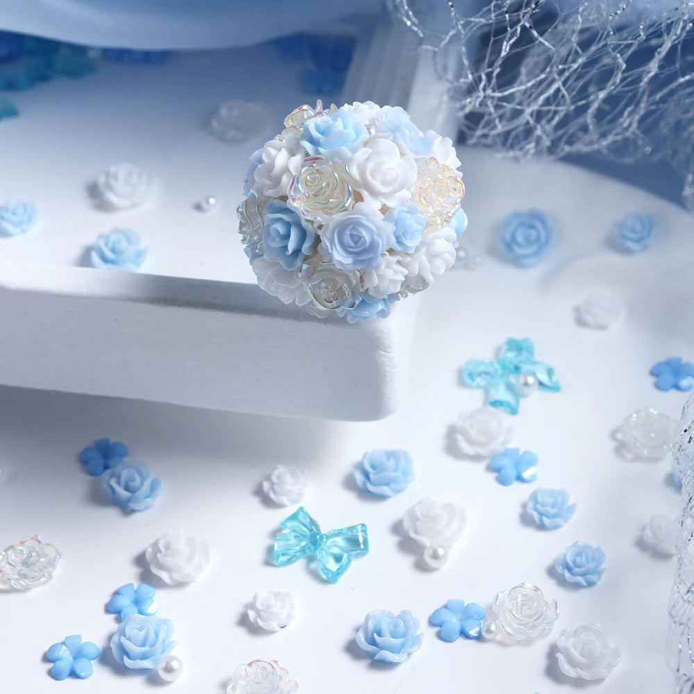 A cluster of blue and white camellia resin flowers used as shaker fillers for DIY crafts.