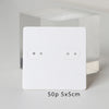 A white square jewelry display card with two oval holes is shown against a clear background.