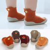 A set of soft-soled baby first walker socks shoes in orange and gray colors.