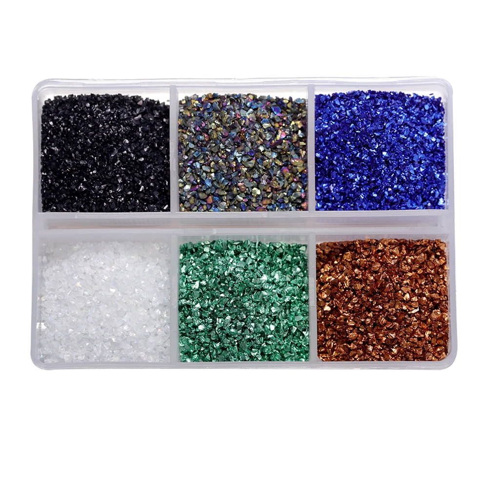 A clear plastic container holds various colors of crushed glass stones including black, multicolored, blue, and green.