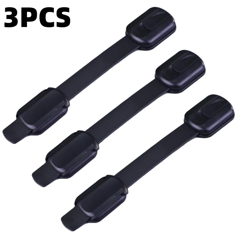 Three black adhesive baby safety locks for cabinets and drawers.