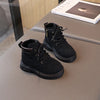 A pair of black kids' winter leather boots with laces and a side zipper resting on a gray surface.