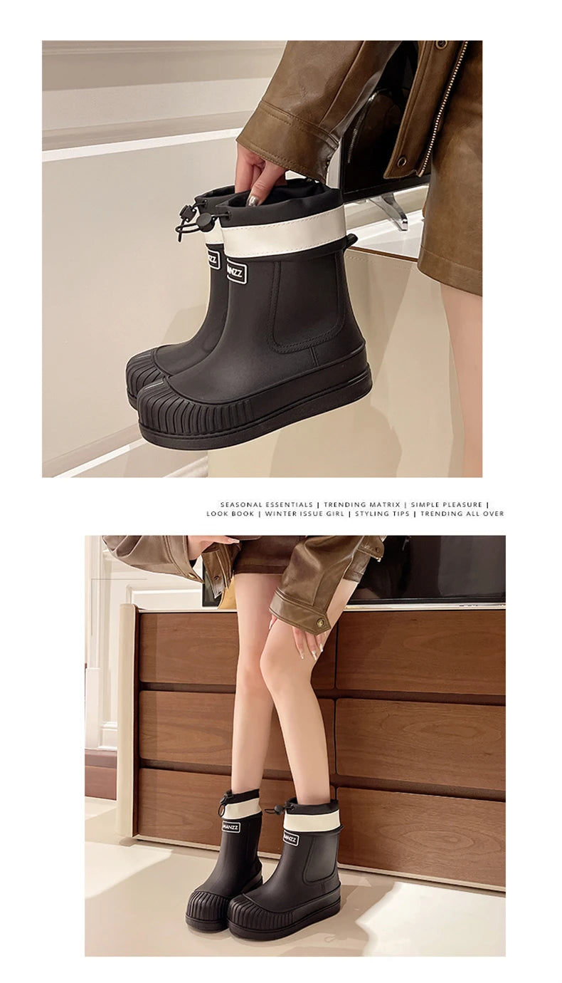 A pair of black waterproof mid-calf rain boots with white trim and non-slip soles shown on a person's leg.