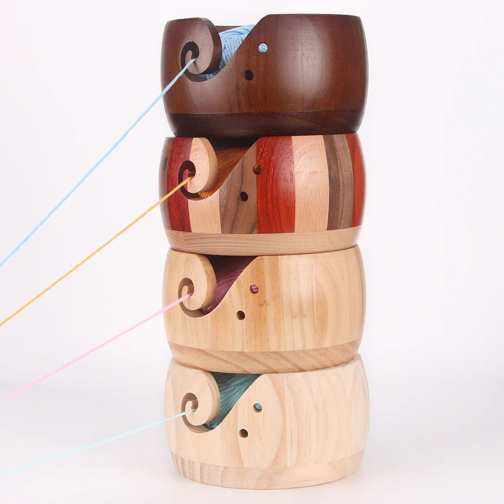 A stack of handcrafted wooden yarn bowls featuring swirl cutout designs in various natural wood tones.
