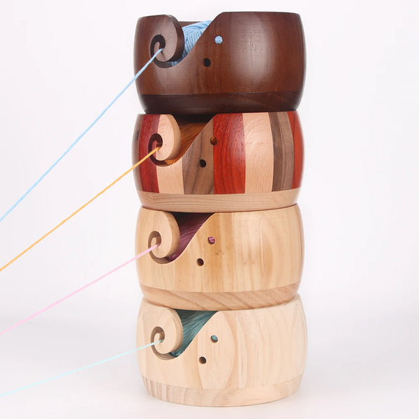 Pila de cuencos artesanales de madera para lana con diseños de recortes en espiral en varios tonos de madera natural.