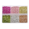 A clear plastic tray filled with various colors of crushed glass stones for resin and craft projects.