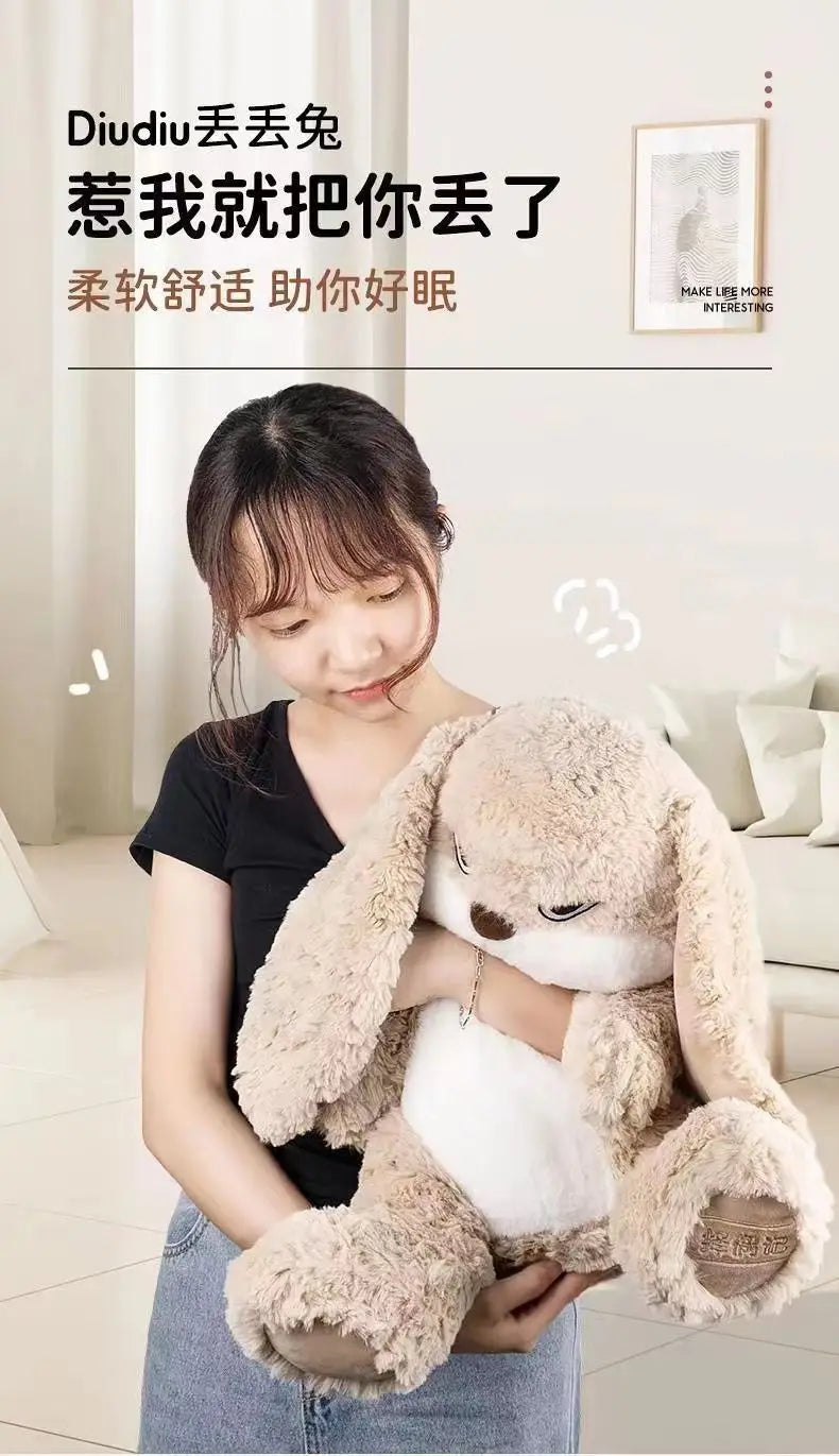 Une femme tient un grand jouet de lapin en peluche brun clair et blanc.