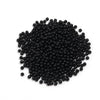 A pile of small, black, round imitation pearl beads for jewelry making.