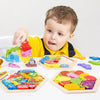 A toddler is interacting with various wooden 3D jigsaw puzzles and learning toys on a white surface.
