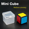 A clear plastic cube puzzle with red, yellow, and blue faces is shown on a dark surface.