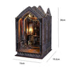 A dark, gothic-style DIY book nook kit featuring miniature furniture and an arched display.