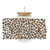 Clear glass tumbler with leopard print UV DTF cup wraps applied to the exterior.