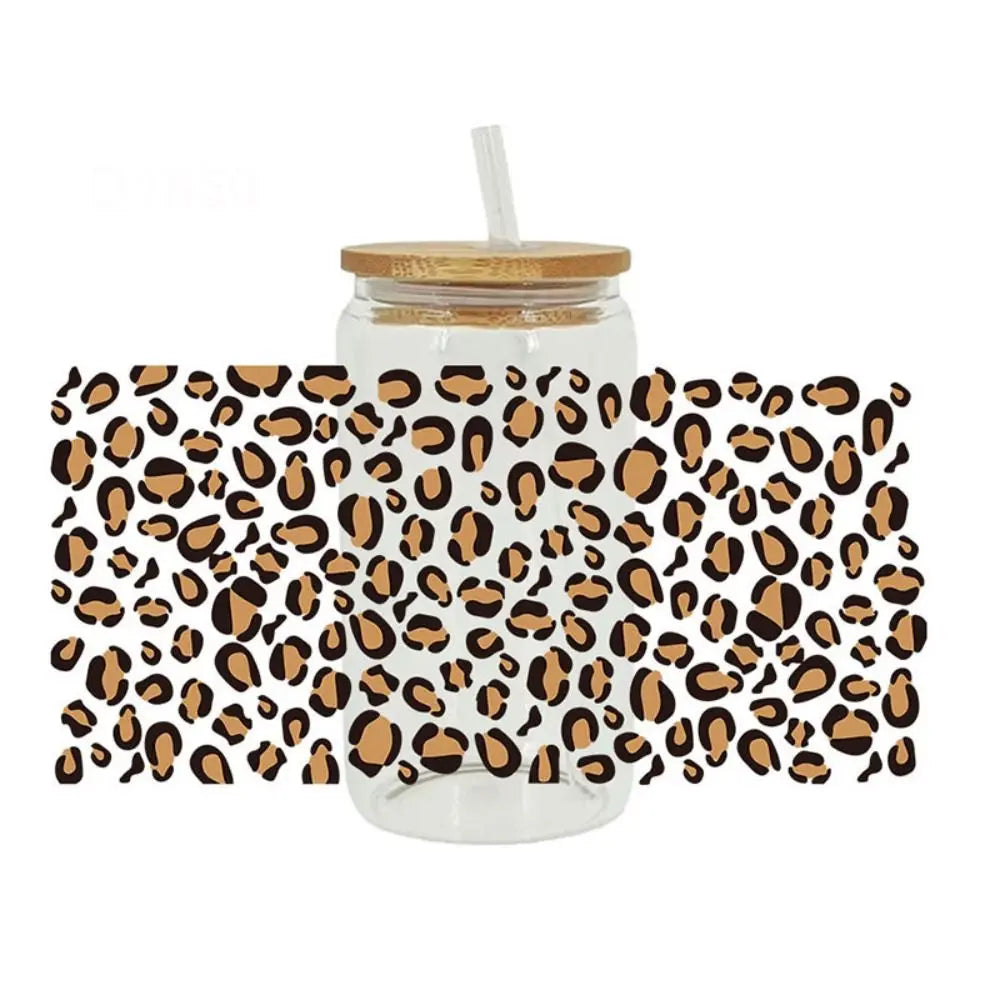 Clear glass tumbler with leopard print UV DTF cup wraps applied to the exterior.