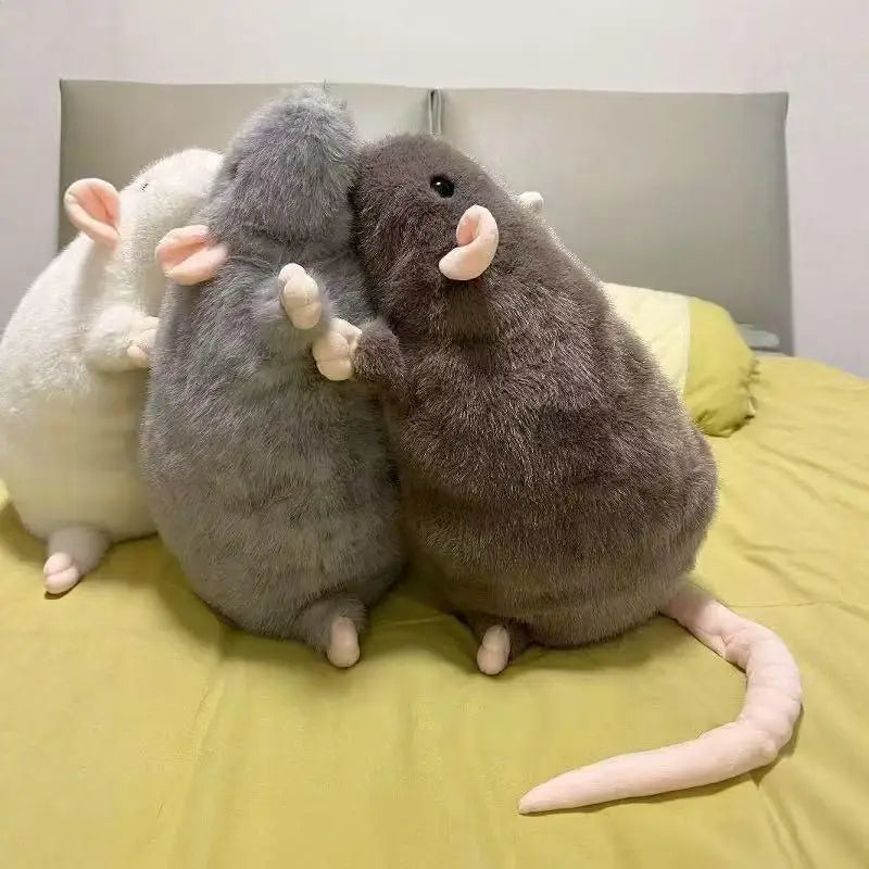 Three realistic plush rat stuffed animals lying together on a yellow bed