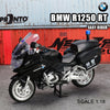 A black BMW R1250 RT motorcycle model in 1:18 scale displayed against a red industrial background.