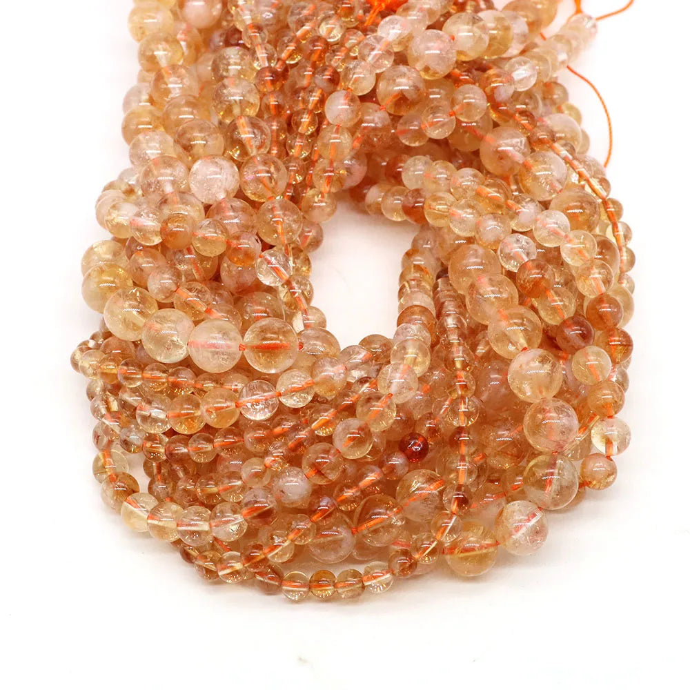 A tangled string of small, translucent orange-brown natural stone round beads for jewelry making.