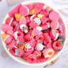 A bowl filled with assorted pink and colorful candy resin flatbacks for DIY crafts and jewelry making
