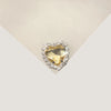 A heart-shaped flatback rhinestone embellishment for DIY crafts, set in a clear setting.