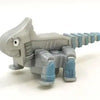 A gray die-cast dinosaur truck toy with a removable dinosaur figure.