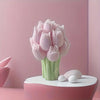 A pink silicone mold shaped like a bouquet of tulips is displayed on a white pedestal against a soft pink background.