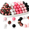 A collection of pink, white, and black silicone beads for DIY jewelry and crafts.