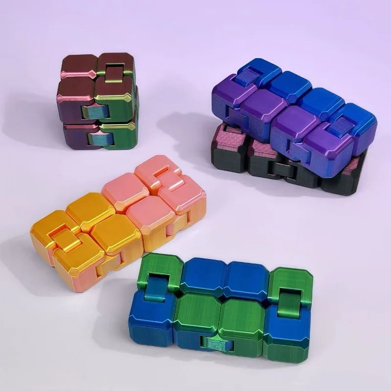 A collection of colorful Infinity Cubes fidget toys in various shades of purple, green, and orange stacked on a white surface