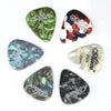 A collection of six Alice celluloid guitar picks in various shades of green and black.