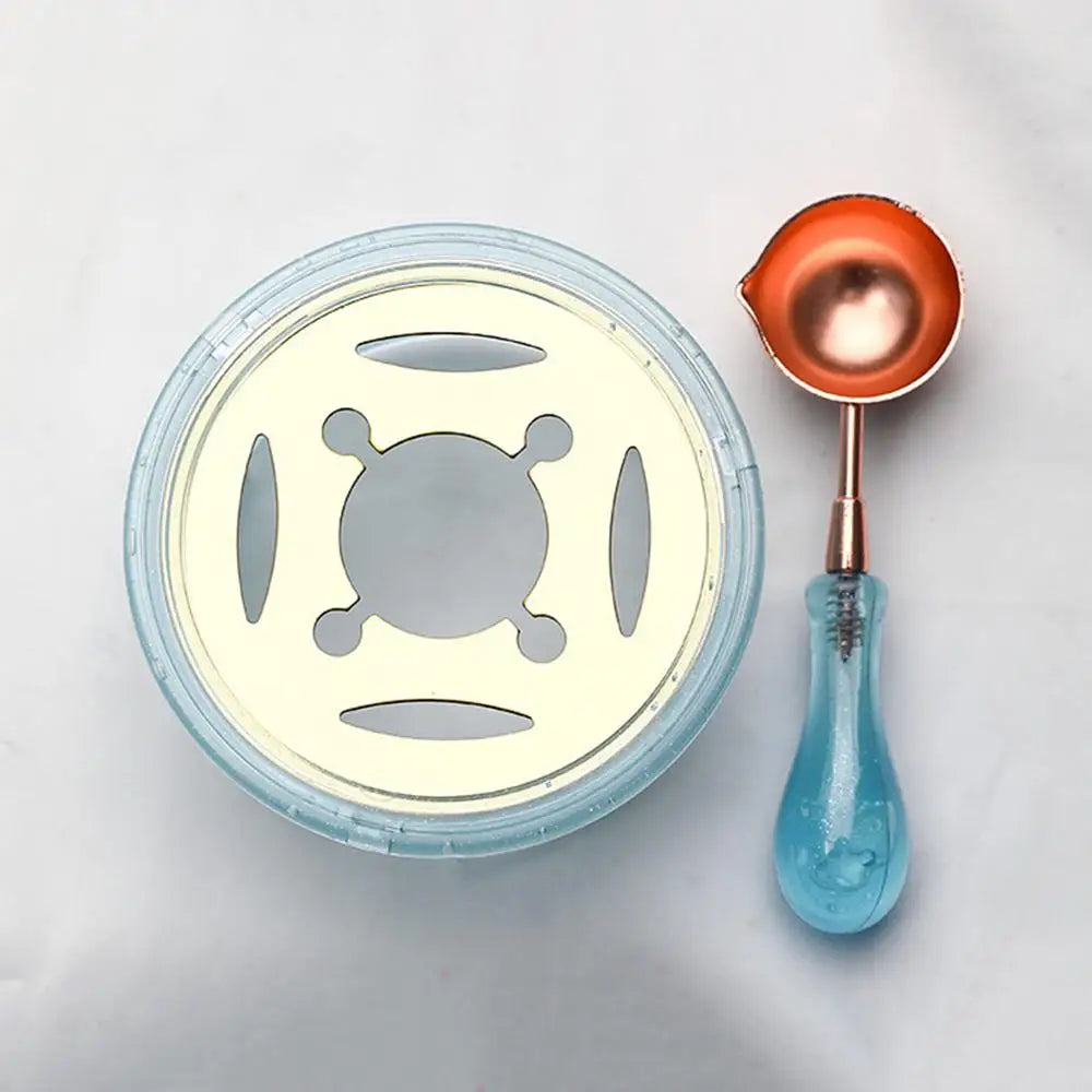 An elegant wax seal melting kit featuring a round silicone mold, a small copper spoon, and a glass heater.