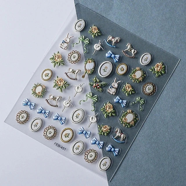 A collection of silver and gold gothic nail art stickers featuring animals, flowers, and decorative elements.