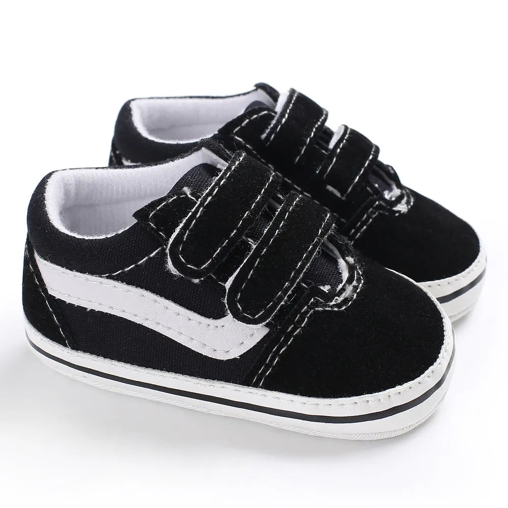 A pair of black and white canvas sneakers with black laces and white soles, shown from the side.