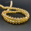 A gold-colored strand of faceted crystal beads used for jewelry making