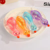 A set of colorful, glittery stretchy duck squeeze toys in pink, orange, and purple resting on a white plate.