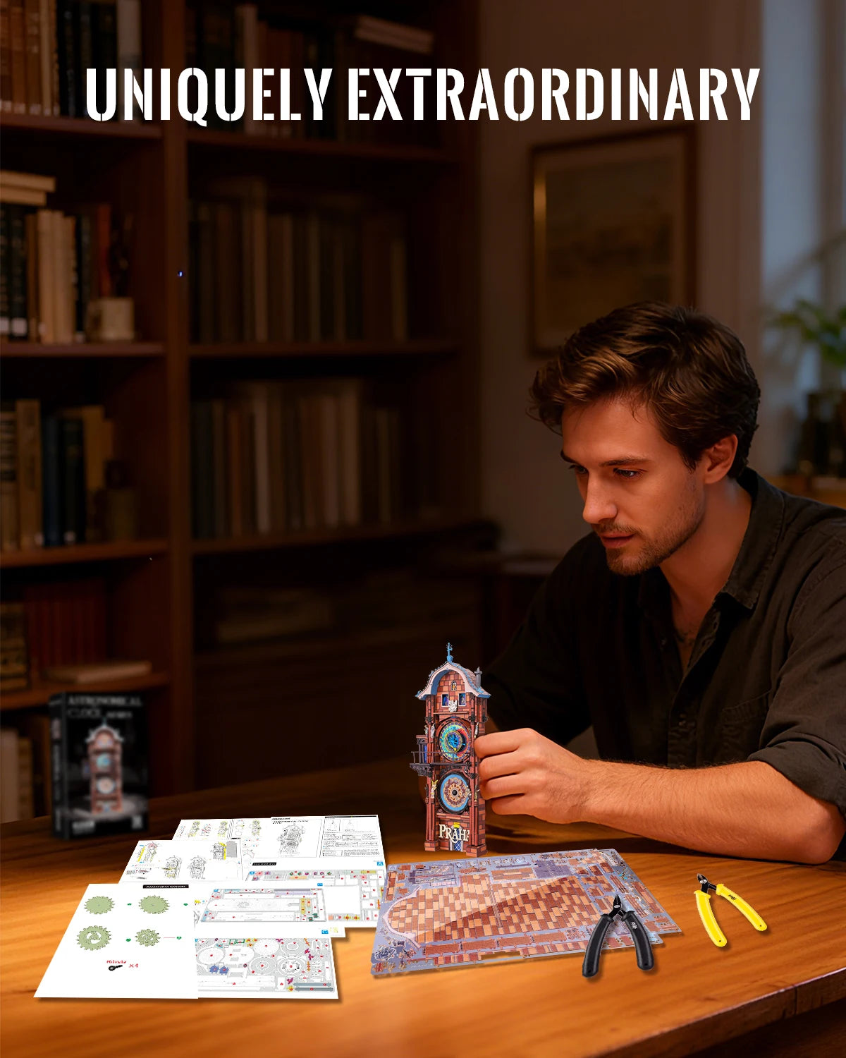 A man is working on a detailed astronomical clock 3D metal puzzle kit on a wooden table surrounded by bookshelves.