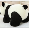A white and black panda plush pillow resting on a white surface.