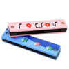 Pink wooden harmonica with a cartoon animal design featuring fish and stars