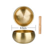 A brass Tibetan singing bowl with a wooden mallet and a separate bowl for sound healing.