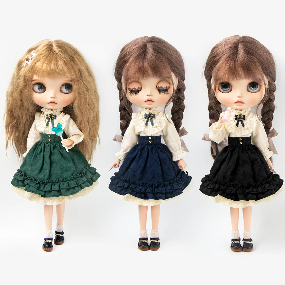 Three dolls with long hair wearing vintage lace maid dress sets in various colors