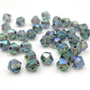 A collection of faceted bicone crystal glass beads in various shades of blue and green.