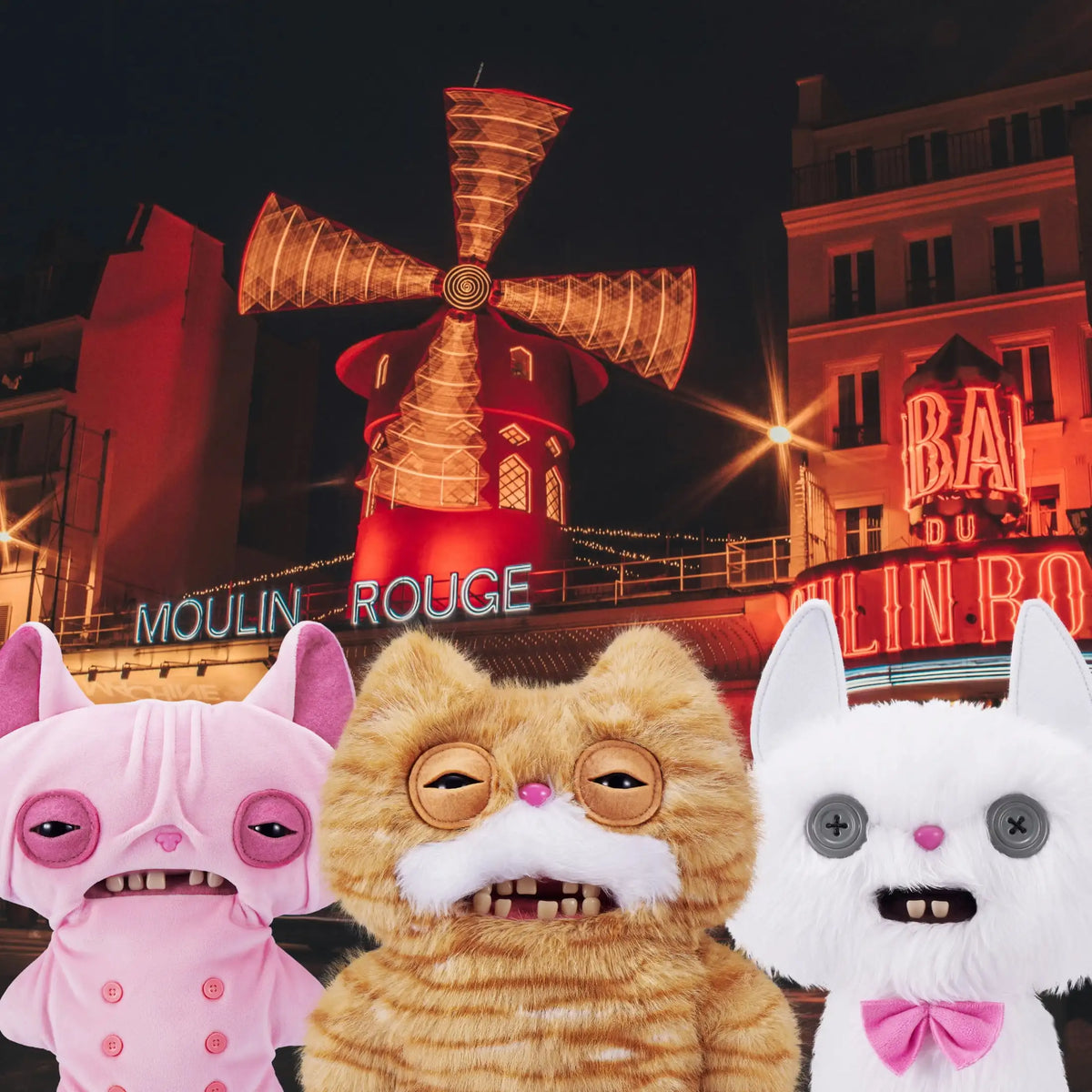 Three plush toys resembling cats in pink, orange, and white are displayed against a city backdrop.