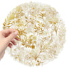 A hand is holding a round sheet of golden botanical transparent PET stickers with intricate floral and leaf designs.
