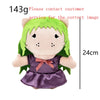 A plush doll of a green-haired character with a purple dress and pink bow.