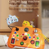 An orange busy machine toy with various switches and lights is shown on a wooden table.