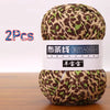 A ball of brown and green leopard print soft chunky yarn, sold as a 2-pack.
