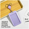 A purple retractable ID badge holder with a keychain is displayed on a wooden tray.