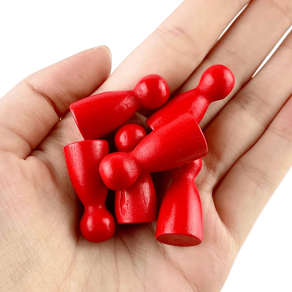 A hand holds a set of twelve wooden game pawns in various shades of red.