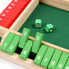 A wooden dice game set featuring red and green numbered blocks and dice on a green board.
