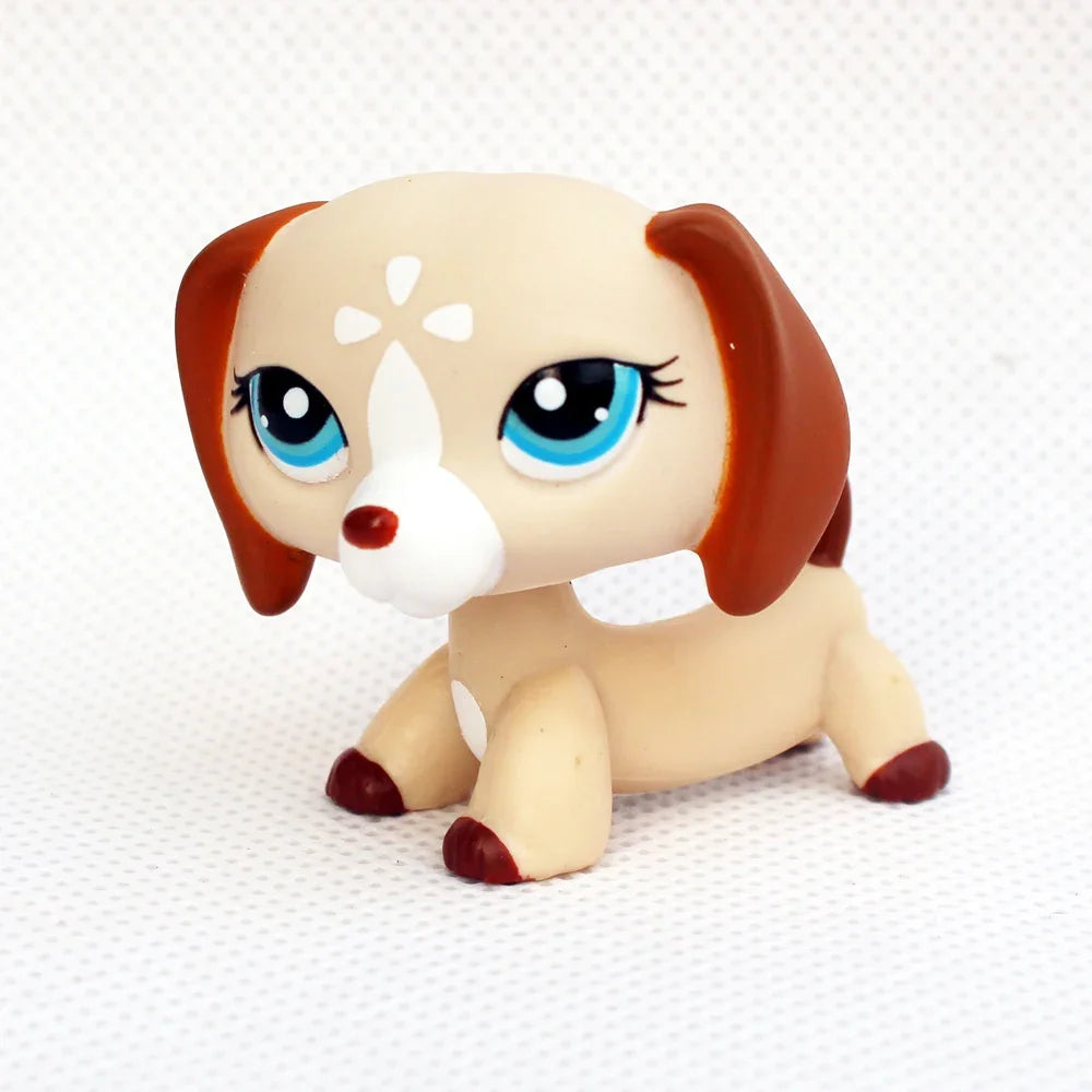 A cute figurine of a dachshund puppy with brown ears and white markings.